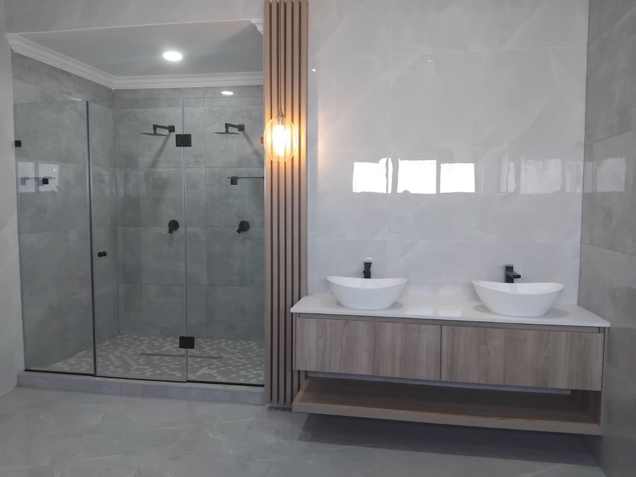 Double vessel-sink bathroom vanity with frameless glass shower