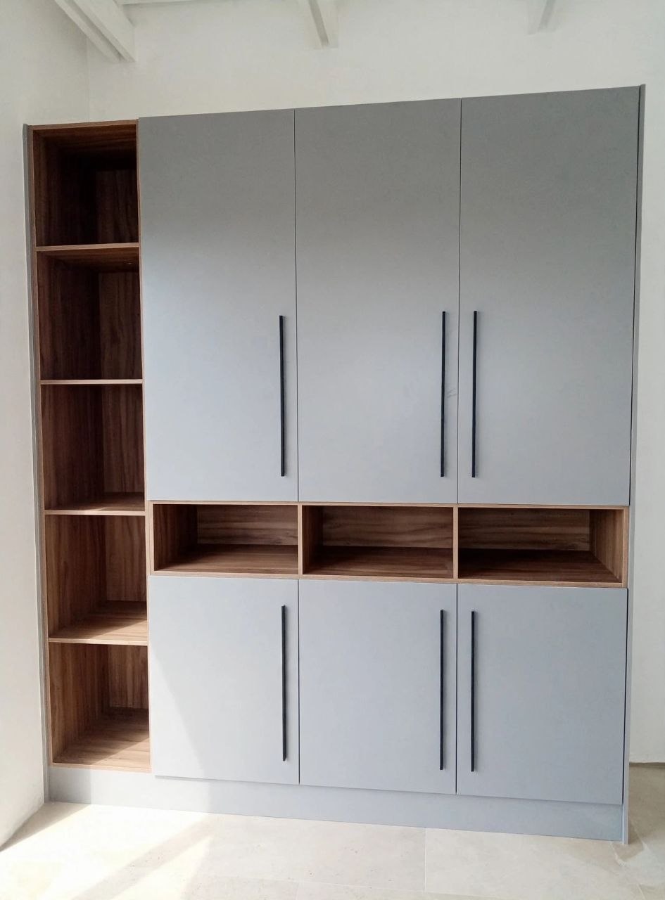 Custom wardrobe with matte grey doors, slim black handles, walnut open shelving and display niches